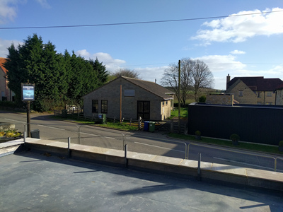 Ext. Day. Pub. The flat roof in progress.