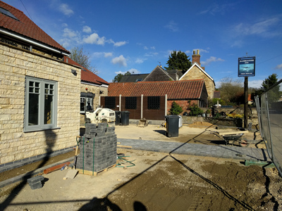 Ext. Day. Pub. The pathway to the main entrance completed.
