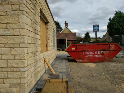 Ext. Day. Pub. The pathway is progressing and cables for the exterior lighting have been fed through the walls.
