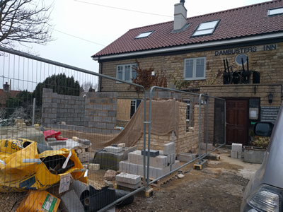 Ext. Day. Pub. Stone walling with window opening, on the East corner.