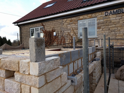 Ext. Day. Pub. The top few courses of stone and block being added to the walls.